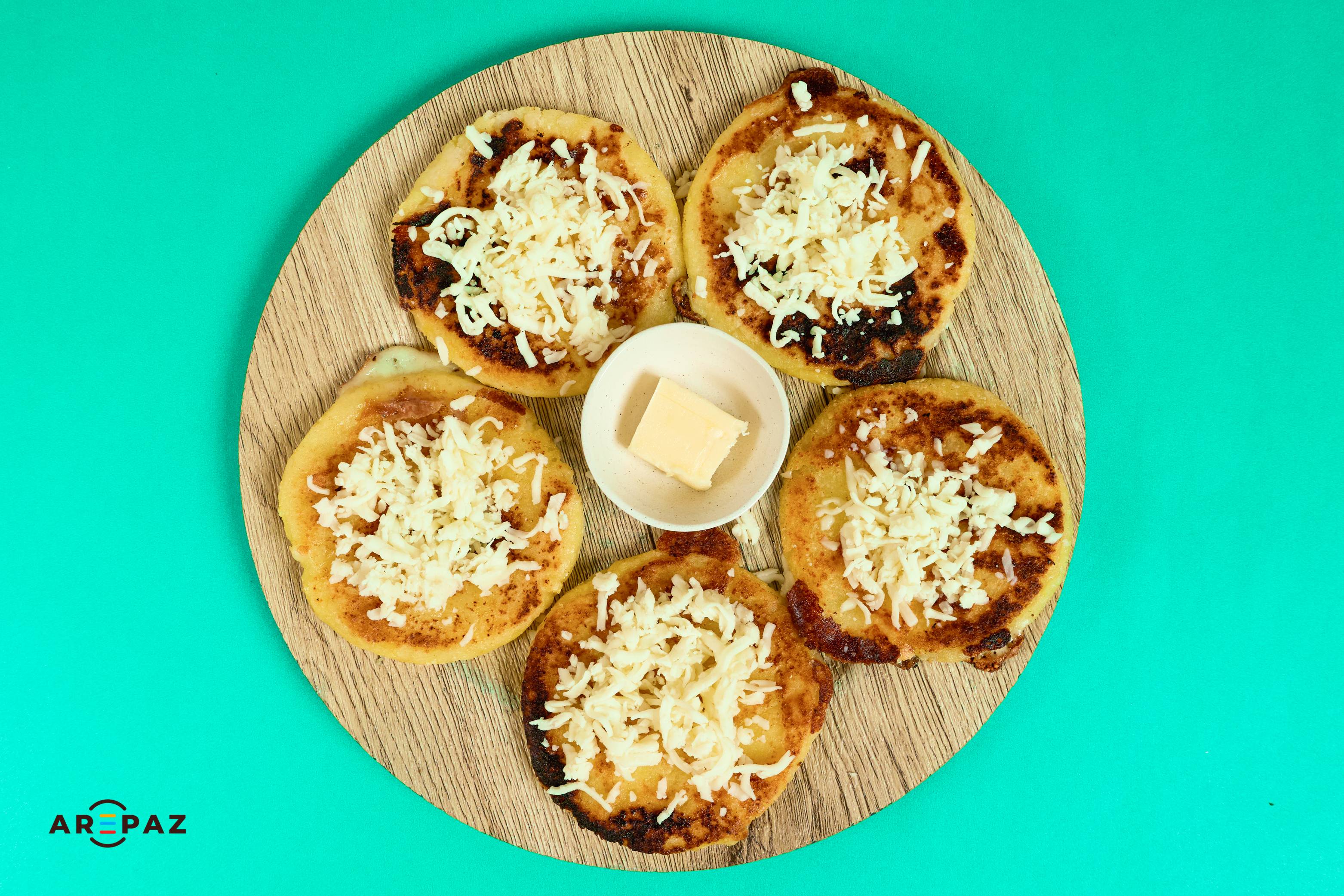 Delicious Colombian arepas with shredded cheese on wooden board